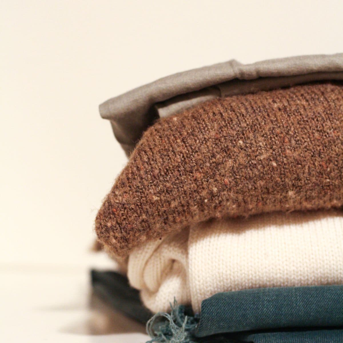 A folded set of garments in stone and cream