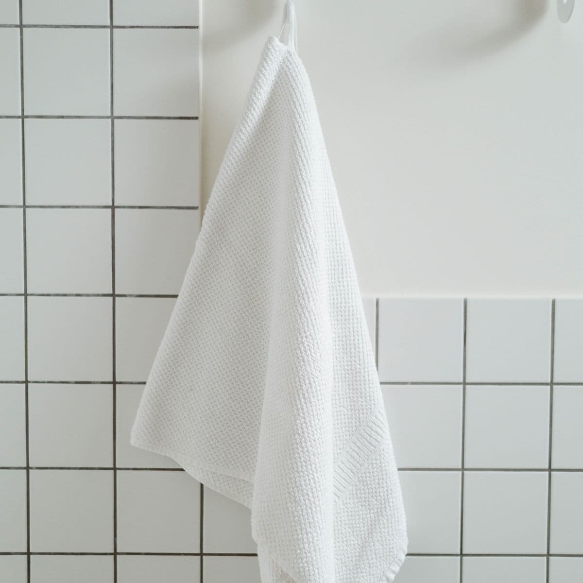 A white waffle towel on a hook