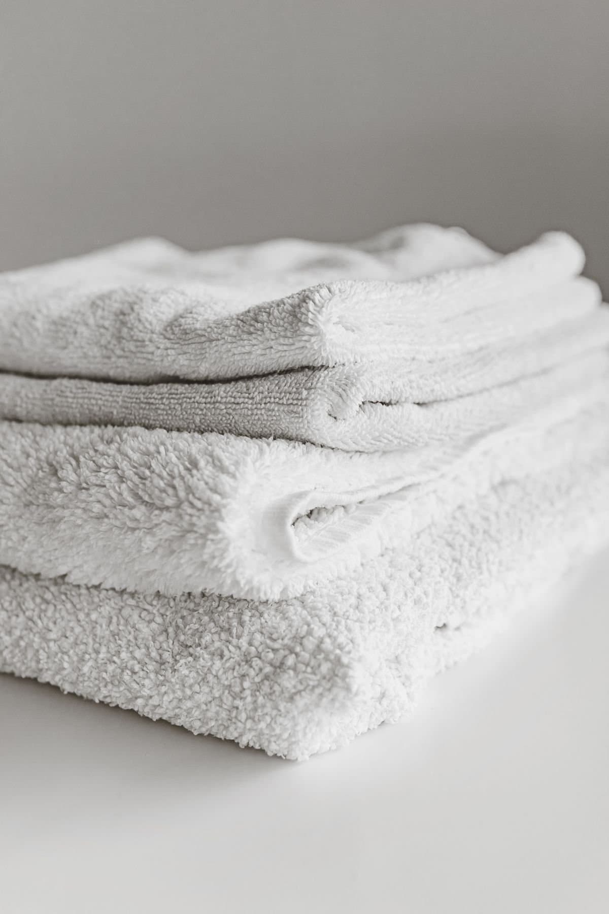 A folded stack of white and grey cotton towels
