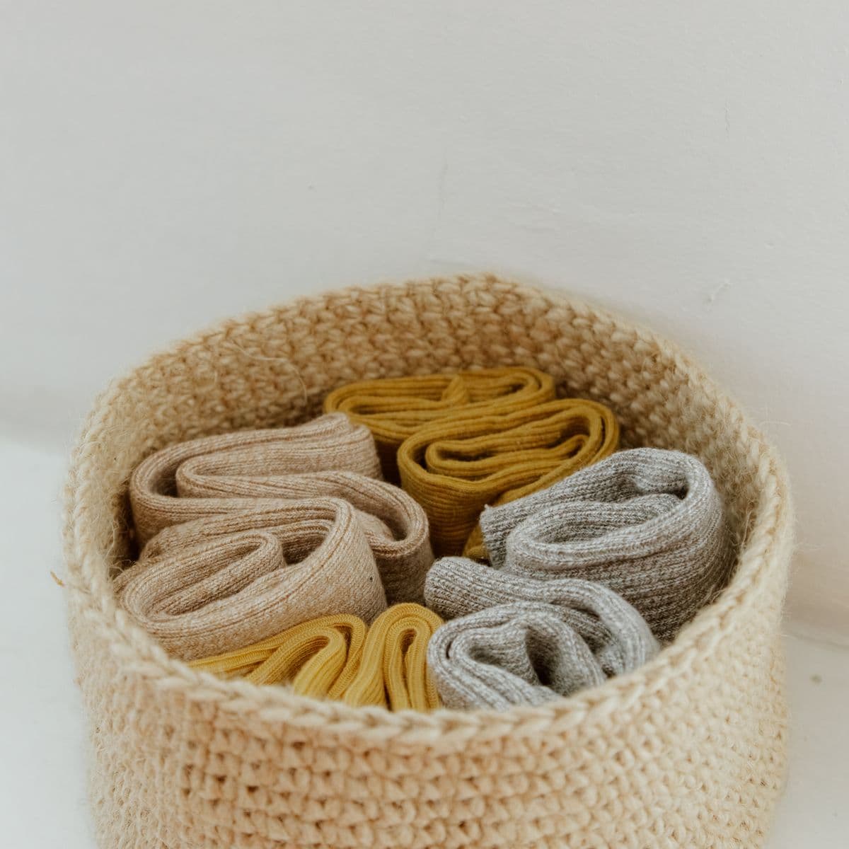 Rolled sports socks in a woven basket