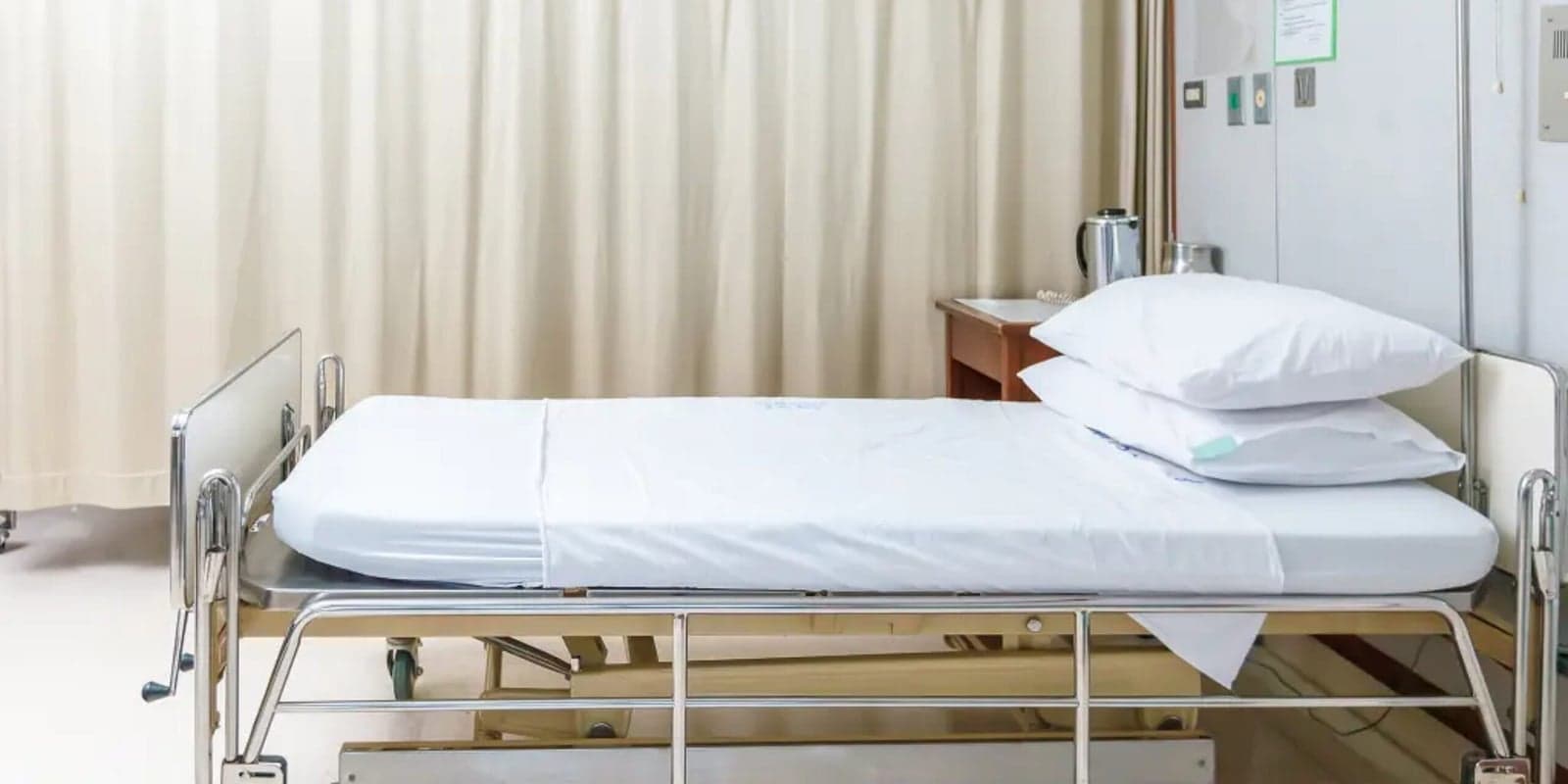 A clean hospital bed in crisp white linen