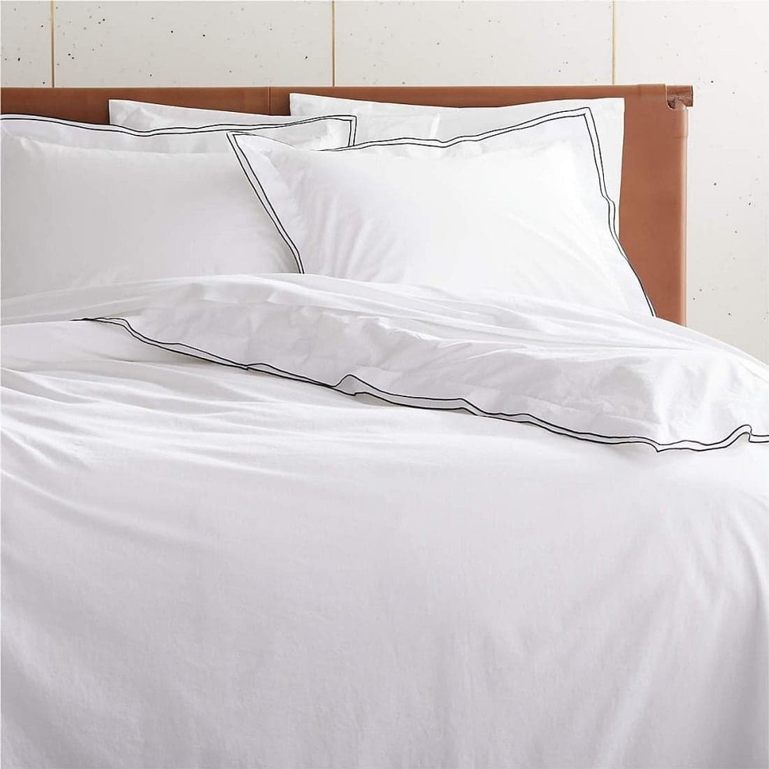 A neatly folded stack of crisp white bed linen